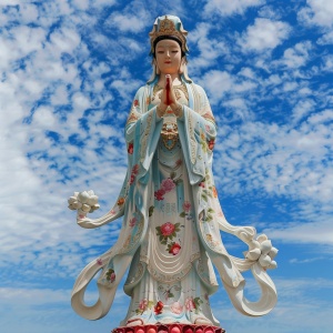 In the blue sky background of the South China Sea, the statue of the female Bodhisattva is resplendent and bright red lotus flowers. The goddess of Guanyin meditates sacred and inviolable. The appearance of the female goddess of Guanyin is kind and the wedding dress is beautiful. The clothing of the female goddess of Guanyin is usually very gorgeous and has a perfect figure. She wears a loose skirt and robe. The robe is embroidered with bright, bright and auspicious patterns, such as lotus cloud patterns, e