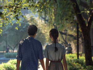 在夏日的早晨，两个恋人在公园散步的背影