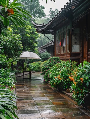 雨后，中国园林风格的绿色植物和花卉静静地生长在石砖石板路的两侧。它下面有一张雨伞桌子。周围一个人也没有，外面阴沉沉的，地上湿漉漉的。安静的环境中有一个精致的木屋，到处都是绿树，这是一个非常美丽的场景。-埃及记第二章第三节