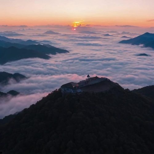 在泰山顶，日出时的景象令人叹为观止。清晨，天边微微泛起鱼肚白，渐渐地，东方的天空被染上了温暖的橙色和粉红色，仿佛一幅美丽的水彩画。云海在山谷中翻腾，宛如波涛起伏，阳光透过云层，洒下金色的光辉，照亮了四周的山峦。n随着时间的推移，太阳缓缓升起，初升的阳光如同一颗璀璨的明珠，逐渐露出地平线，整个山顶瞬间被金色的光芒包围。山风轻拂，带来一丝清凉，空气中弥漫着清新的气息，仿佛一切都在这一刻苏醒。n此时，站在泰山顶，俯瞰四周，连绵的群山在晨光中显得更加雄伟壮丽，远处的山峰隐约可见，宛如一幅壮丽的山水画。日出时的宁静与壮观，让人心旷神怡，仿佛置身于人间仙境，令人不禁感叹大自然的神奇与美丽。